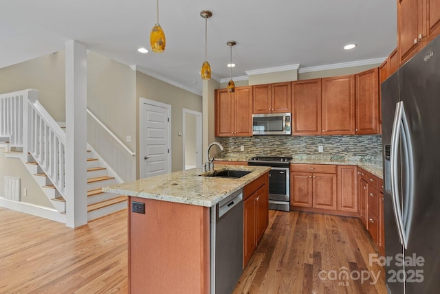 38 Unadilla Aly, Asheville, NC 28803 - kitchen featuring appliances with stainless steel finishes, a sink, wood finished floors, backsplash, and light stone counters