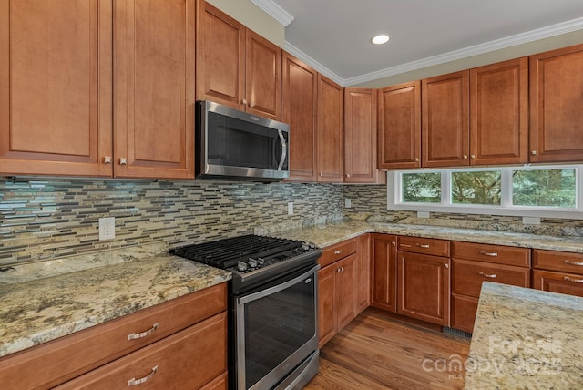 38 Unadilla Aly, Asheville, NC 28803 - kitchen featuring stainless steel appliances, light wood-style floors, ornamental molding, light stone countertops, and decorative backsplash