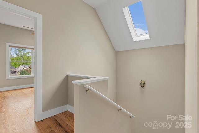 38 Unadilla Aly, Asheville, NC 28803 - staircase featuring a skylight, vaulted ceiling, baseboards, and wood finished floors