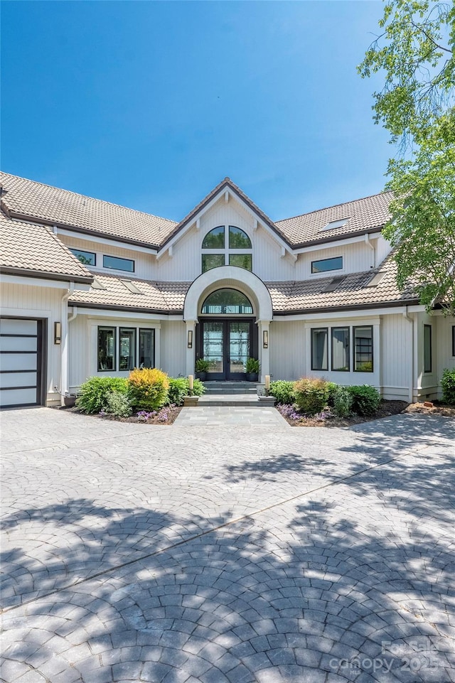 3386 Governors Island Dr, Denver, NC 28037 - view of front of home with a tile roof, french doors, decorative driveway, and a garage