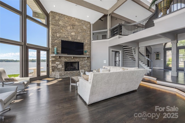 3386 Governors Island Dr, Denver, NC 28037 - living room featuring high vaulted ceiling, dark wood-type flooring, a water view, a fireplace, and stairs