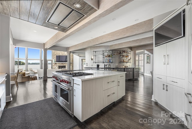 3386 Governors Island Dr, Denver, NC 28037 - kitchen with range with two ovens, open floor plan, a spacious island, dark wood-style floors, and beamed ceiling