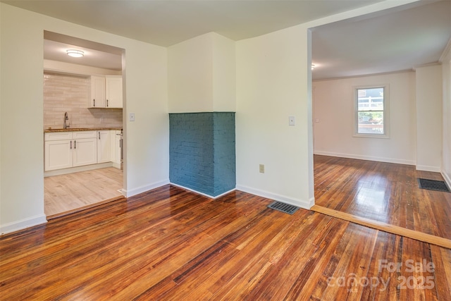 9 N St, Weaverville, NC 28787 - unfurnished living room with wood-type flooring, a sink, and baseboards