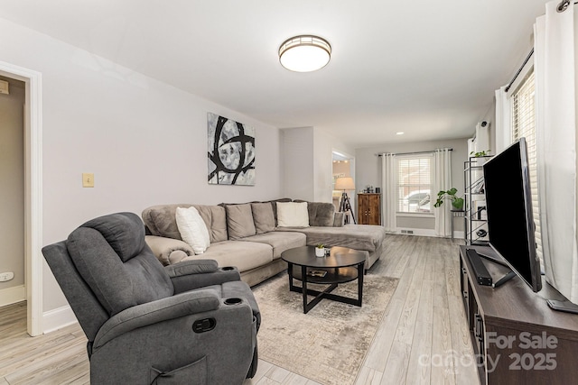 living room with light wood finished floors and baseboards