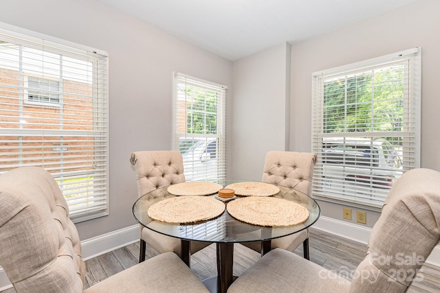 dining space with baseboards and wood finished floors