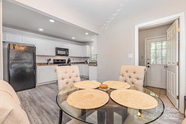 dining space with light wood-style floors and recessed lighting