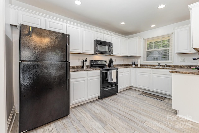 kitchen featuring black appliances, a sink, light wood-style flooring, white cabinetry, and recessed lighting