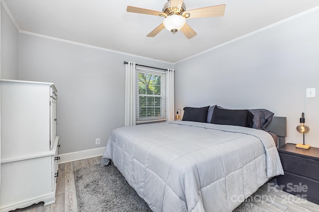 bedroom with wood finished floors, crown molding, baseboards, and ceiling fan