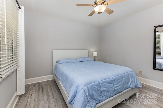bedroom with wood finished floors, baseboards, and ceiling fan