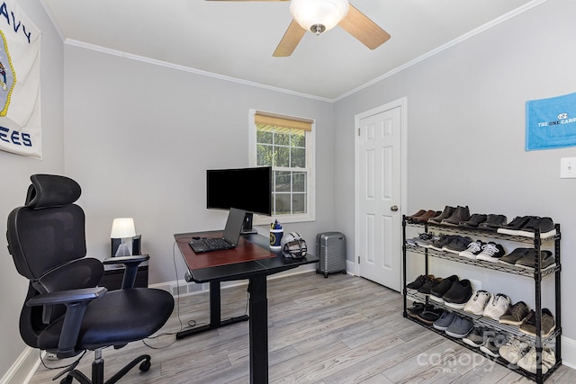 home office with light wood-style floors, ornamental molding, a ceiling fan, and baseboards