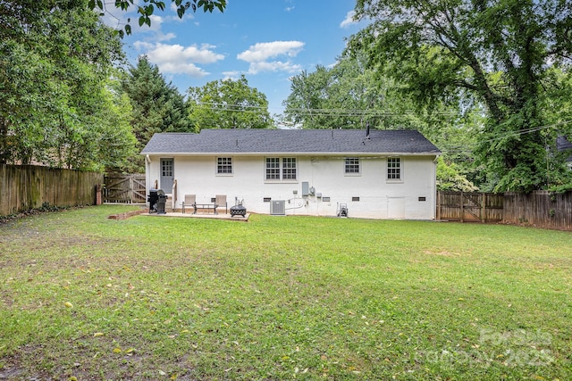 back of property with central air condition unit, a gate, a patio, crawl space, and view of scattered trees