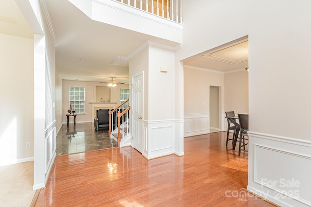 15037 Taylor Ridge Ln Unit 25, Charlotte, NC 28273 - foyer entrance featuring crown molding, wood finished floors, wainscoting, ceiling fan, and a fireplace