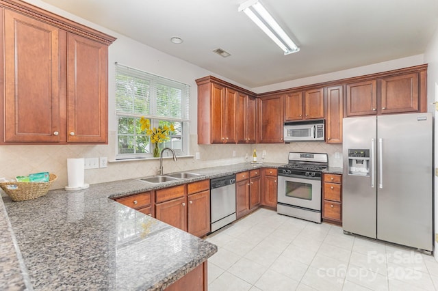 15037 Taylor Ridge Ln Unit 25, Charlotte, NC 28273 - kitchen featuring appliances with stainless steel finishes, a sink, brown cabinetry, and backsplash