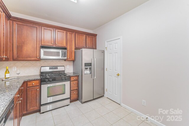 15037 Taylor Ridge Ln Unit 25, Charlotte, NC 28273 - kitchen featuring appliances with stainless steel finishes, backsplash, stone counters, and light tile patterned flooring