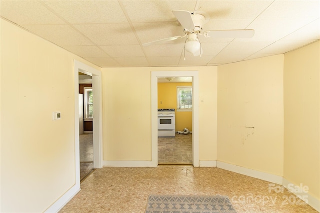 spare room with baseboards, a paneled ceiling, and ceiling fan