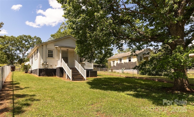 rear view of house featuring a yard, a fenced backyard, central AC, and crawl space