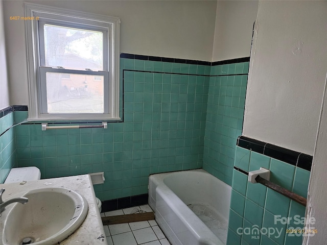 6407 Market St, Charlotte, NC 28215 - bathroom featuring a sink, tile walls, tile patterned floors, wainscoting, and a tub