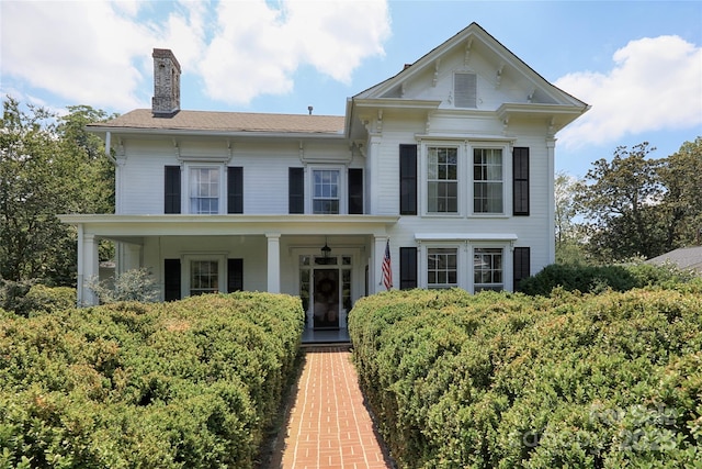 view of front of home featuring covered porch and a chimney