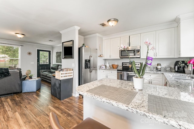 201 Easy St, Concord, NC 28027 - kitchen with appliances with stainless steel finishes, light stone counters, wood finished floors, white cabinetry, and ornamental molding