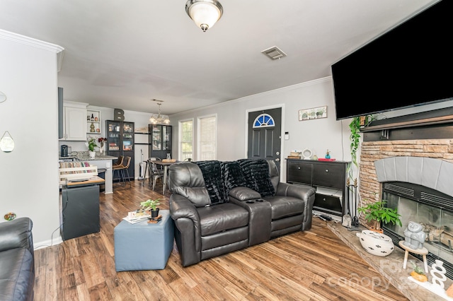 201 Easy St, Concord, NC 28027 - living area with a chandelier, ornamental molding, light wood-style flooring, a stone fireplace, and baseboards