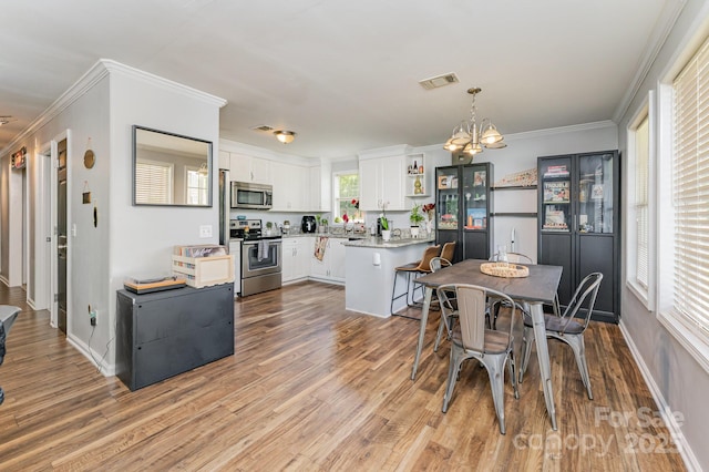 201 Easy St, Concord, NC 28027 - dining space with light wood finished floors, a chandelier, ornamental molding, and baseboards