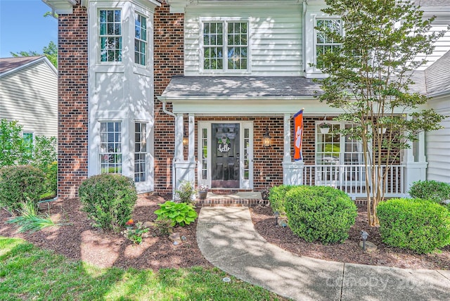 7600 Ridgefield Dr, Charlotte, NC 28269 - doorway to property featuring covered porch and brick siding