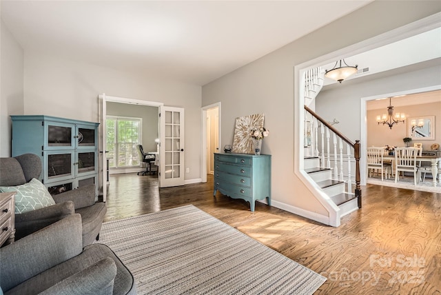 7600 Ridgefield Dr, Charlotte, NC 28269 - living area with stairs, french doors, wood finished floors, baseboards, and a notable chandelier