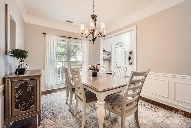 7600 Ridgefield Dr, Charlotte, NC 28269 - dining area with crown molding, visible vents, wood finished floors, and a notable chandelier