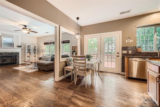 7600 Ridgefield Dr, Charlotte, NC 28269 - dining space with light wood-type flooring, ceiling fan, a fireplace, and visible vents