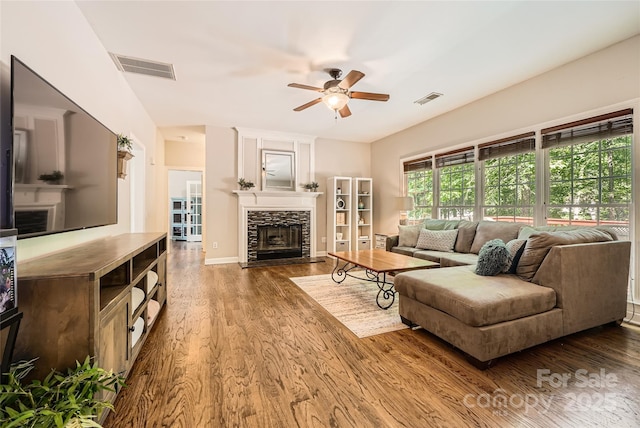 7600 Ridgefield Dr, Charlotte, NC 28269 - living area with a fireplace, a ceiling fan, visible vents, and wood finished floors