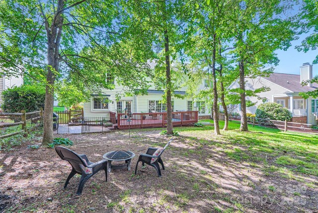 7600 Ridgefield Dr, Charlotte, NC 28269 - view of yard featuring a fire pit, a deck, and a fenced backyard