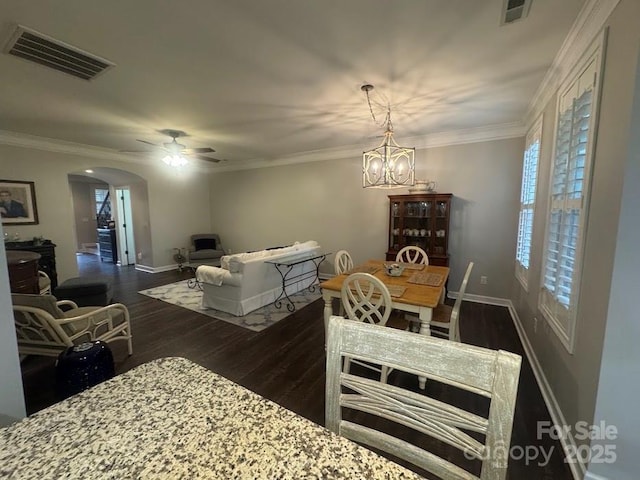 dining area with arched walkways, dark wood-style flooring, baseboards, ceiling fan, and a chandelier