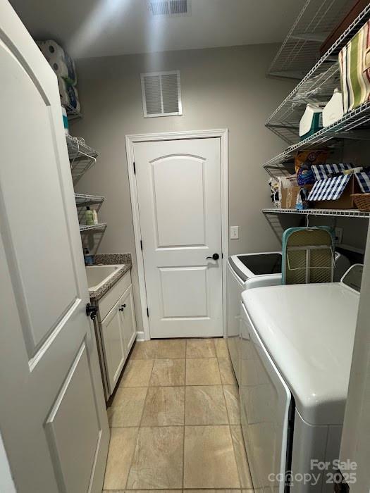 washroom with washer and dryer and cabinet space