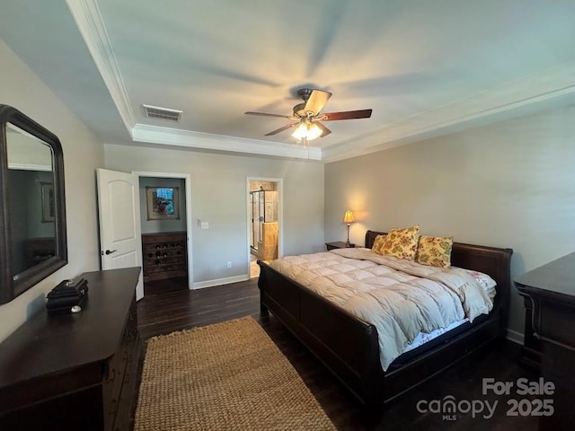 bedroom with dark wood-type flooring, ornamental molding, baseboards, a ceiling fan, and a raised ceiling