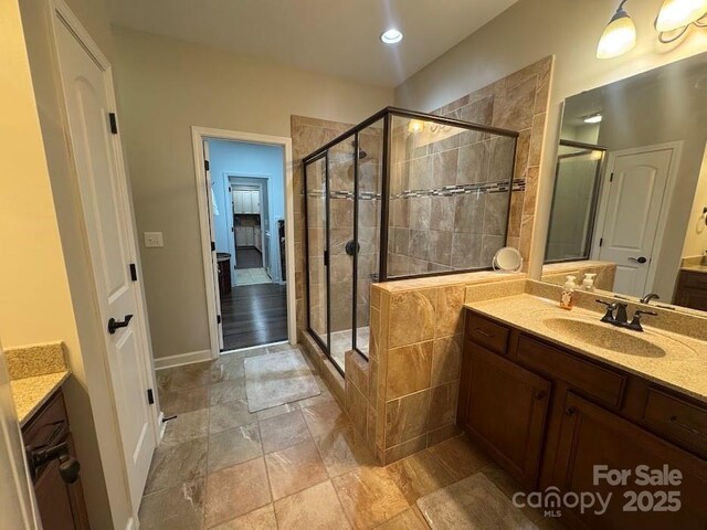 bathroom featuring a shower stall, vanity, stone finish flooring, recessed lighting, and baseboards