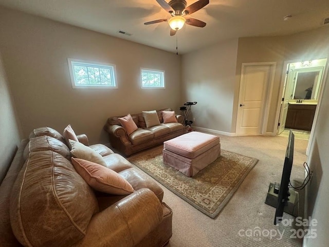 living area featuring ceiling fan, carpet flooring, and baseboards
