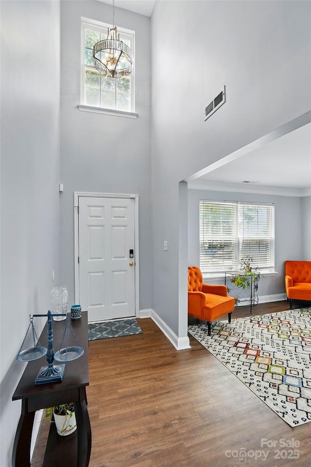 10431 Plantain Ct, Charlotte, NC 28213 - foyer entrance with a towering ceiling, wood finished floors, baseboards, healthy amount of natural light, and a chandelier