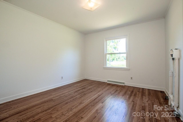 empty room featuring crown molding, baseboards, and dark wood finished floors