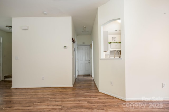 10016 Lawing School Rd, Charlotte, NC 28214 - empty room with wood finished floors, arched walkways, and a smoke detector