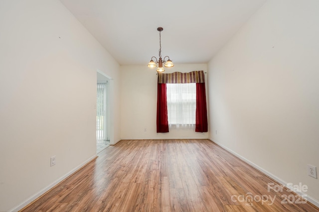 10016 Lawing School Rd, Charlotte, NC 28214 - unfurnished room featuring plenty of natural light, a chandelier, and light wood-style floors