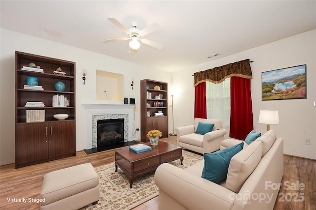 10016 Lawing School Rd, Charlotte, NC 28214 - living area featuring light wood finished floors, ceiling fan, a tile fireplace, and built in features