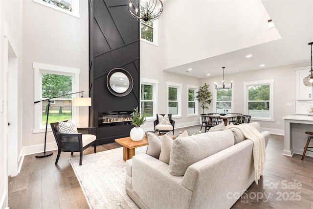 9527 Walkers Ferry Rd, Charlotte, NC 28214 - living room featuring a chandelier, a towering ceiling, wood finished floors, plenty of natural light, and recessed lighting
