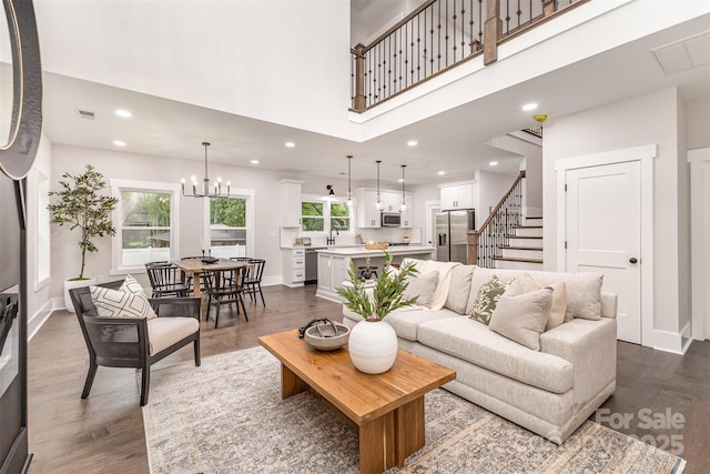9527 Walkers Ferry Rd, Charlotte, NC 28214 - living area featuring dark wood-type flooring, a high ceiling, recessed lighting, a chandelier, and stairway