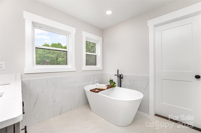 9527 Walkers Ferry Rd, Charlotte, NC 28214 - full bath featuring a freestanding tub, tile walls, vanity, wainscoting, and recessed lighting