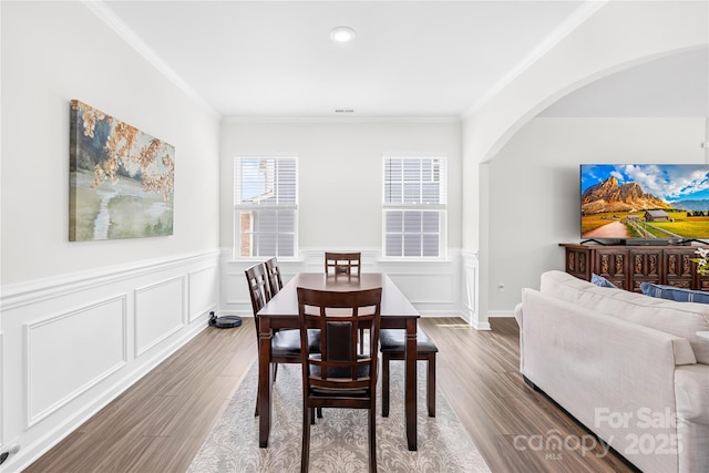 191 Tackle Box Dr, Troutman, NC 28166 - dining area featuring arched walkways, dark wood-style floors, crown molding, a wainscoted wall, and recessed lighting