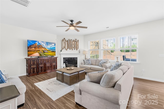 191 Tackle Box Dr, Troutman, NC 28166 - living area featuring wood finished floors, ceiling fan, a fireplace, and baseboards