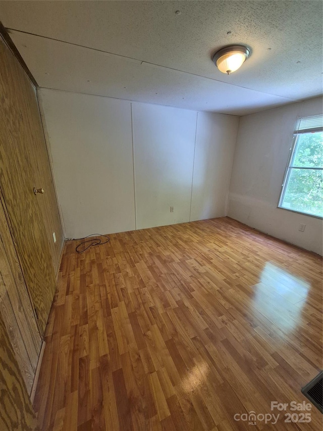 empty room featuring visible vents and wood finished floors