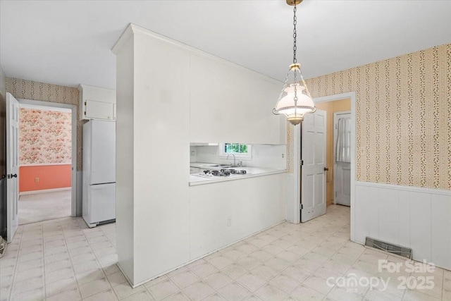 8017 Prince George Rd, Charlotte, NC 28210 - unfurnished dining area with wallpapered walls, a wainscoted wall, and light floors