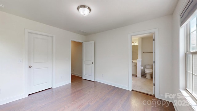 14506 Knowledge Cir, Charlotte, NC 28277 - unfurnished bedroom with wood finished floors, baseboards, and ensuite bath