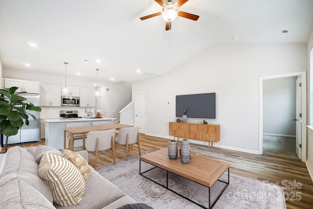 living room with light wood-type flooring, baseboards, a ceiling fan, and recessed lighting